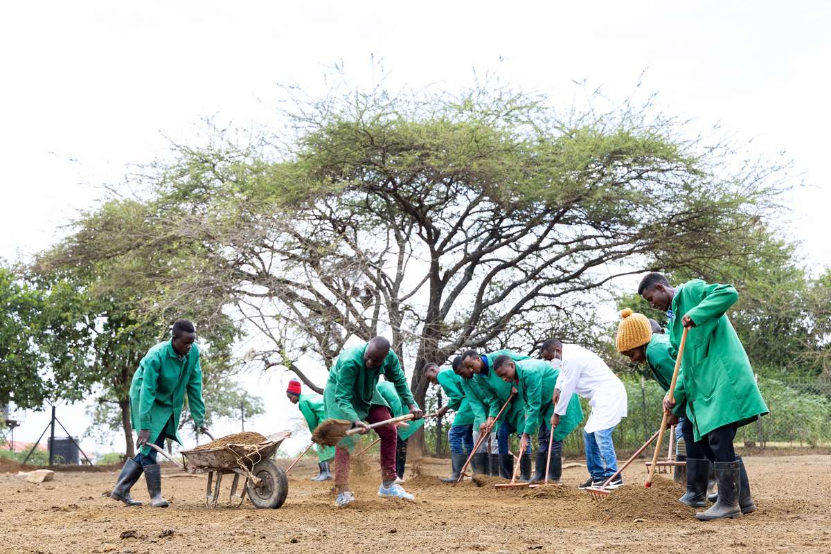 Agriculture trainees during a practical session harvesting animal manure