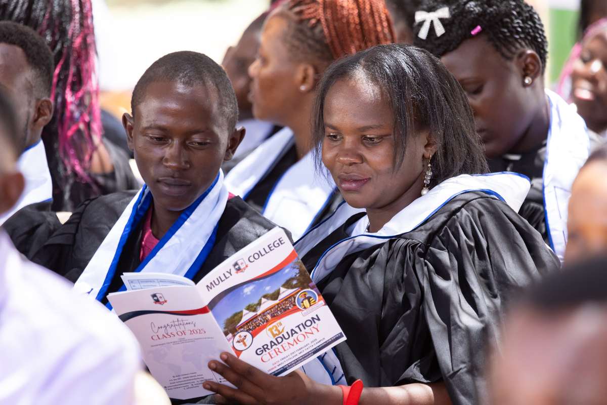 Two graduands reading the graduation ceremony programme