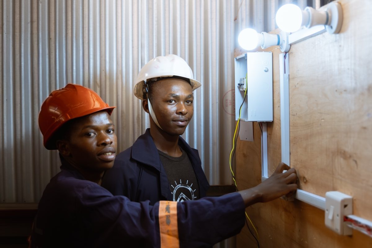 Electrical installation trainees working on a wiring board