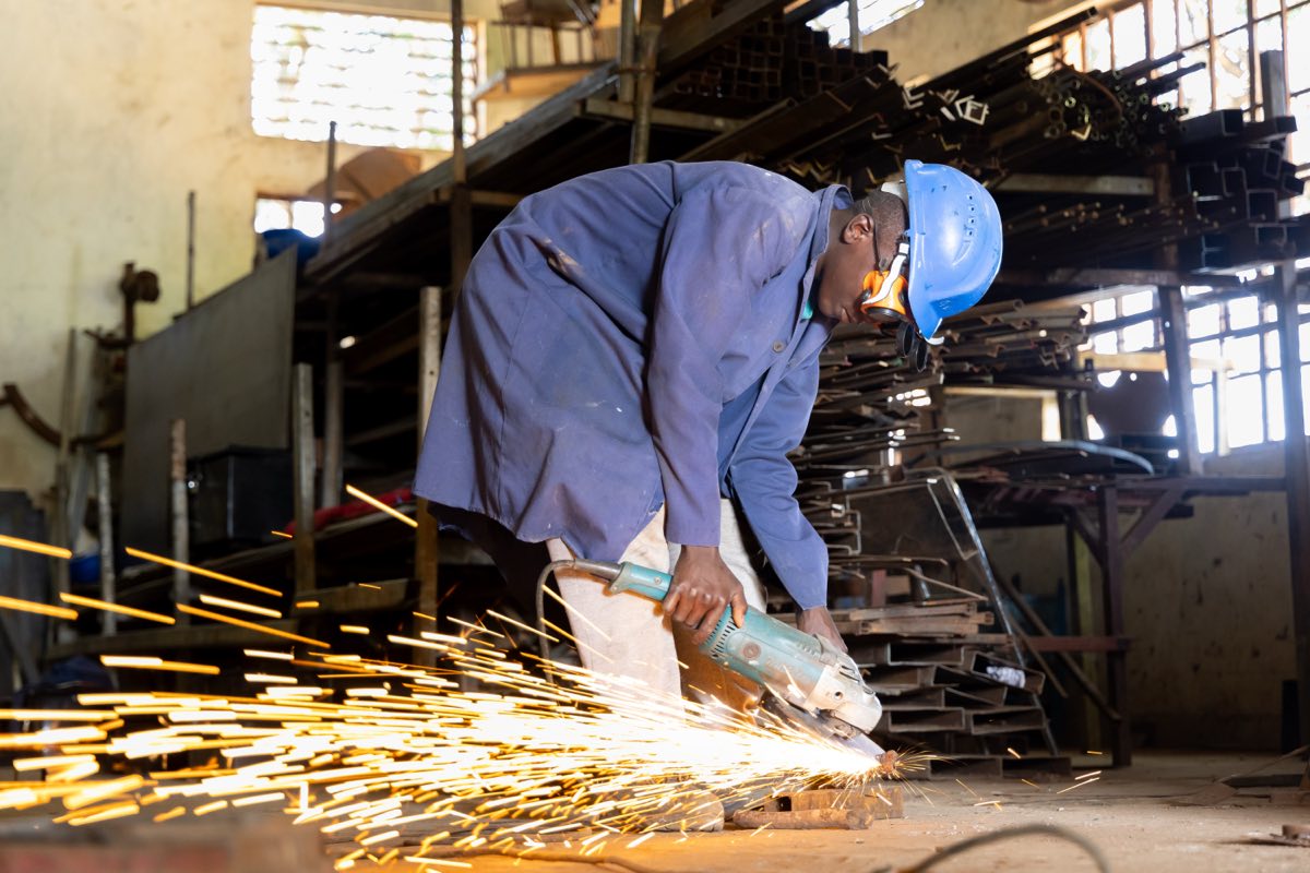 A trainee grinding metal in the college fabrication workshop