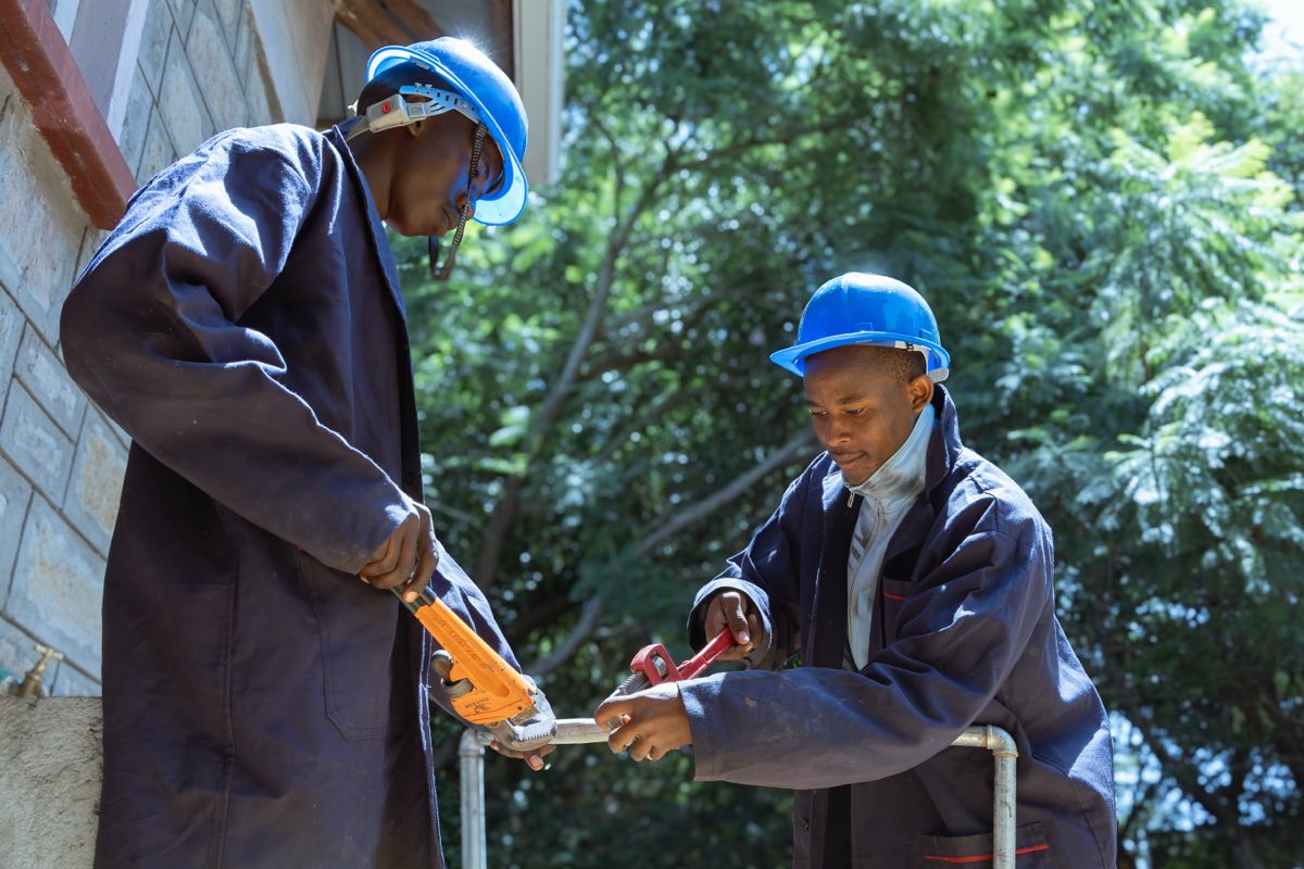Plumbing trainees working with pipes and fittings